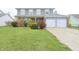 Charming two-story home with a well-manicured lawn and an attached two-car garage at 7421 Rogers Dr, Indianapolis, IN 46214