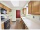 Kitchen featuring wooden cabinets, standard appliances, and a view into the red dining room at 7421 Rogers Dr, Indianapolis, IN 46214