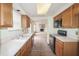 Kitchen with outdated cabinets, appliances, double sink, and view of the living room at 7421 Rogers Dr, Indianapolis, IN 46214