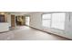 Living room with a slider door to the deck, kitchen access, and three large windows at 7421 Rogers Dr, Indianapolis, IN 46214