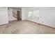 Living room showing a stairway, large window, and neutral walls, requiring updates at 7421 Rogers Dr, Indianapolis, IN 46214