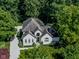 Aerial view of a two-story home featuring a large, well-manicured yard, a multi-car driveway, and mature trees at 7957 Preservation Dr, Indianapolis, IN 46278