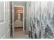 Bathroom featuring black and white tiled floor, decorative shower curtain, and vanity visible in mirror at 7957 Preservation Dr, Indianapolis, IN 46278