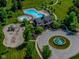 Aerial view of the community pool, park, clubhouse, and playground featuring mature trees, well-manicured lawns, and winding sidewalks at 7957 Preservation Dr, Indianapolis, IN 46278