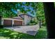 Long driveway leads to a two-car garage and a basketball court, all beautifully framed by lush trees and a well-maintained yard at 7957 Preservation Dr, Indianapolis, IN 46278