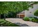 Spacious driveway leading to a two-car garage, complemented by a basketball hoop, lush greenery, and professional landscaping at 7957 Preservation Dr, Indianapolis, IN 46278