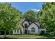 Charming exterior view of a two-story home with brick facade, arched windows, landscaped front yard, and mature trees at 7957 Preservation Dr, Indianapolis, IN 46278