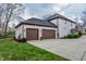 Attached two-car garage with dark doors complementing the white brick exterior of the house at 7957 Preservation Dr, Indianapolis, IN 46278