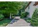 Sideyard view featuring a driveway framed by manicured landscaping, leading to the home's brick facade and a basketball court at 7957 Preservation Dr, Indianapolis, IN 46278