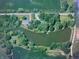 Aerial view of property with pond and surrounding trees, showing unique landscape and water feature at 8201 E 250 S, Zionsville, IN 46077