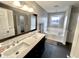 Bathroom with dual sinks, granite countertops, window over tub, and dark tile flooring at 8201 E 250 S, Zionsville, IN 46077