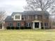 Traditional two-story brick home featuring dark shutters, manicured shrubs, and a well-maintained lawn at 8201 E 250 S, Zionsville, IN 46077