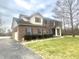 Traditional brick home featuring an attached garage, dark shutters, and a well-maintained lawn at 8201 E 250 S, Zionsville, IN 46077