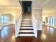 Beautiful staircase with hardwood steps and white railings, complemented by hardwood flooring and light walls at 8201 E 250 S, Zionsville, IN 46077