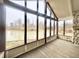 Sunroom featuring a stone fireplace, ceiling fan, and floor to ceiling windows overlooking the pond at 8201 E 250 S, Zionsville, IN 46077