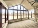 Sunroom featuring a stone fireplace, ceiling fan, and floor to ceiling windows overlooking the pond at 8201 E 250 S, Zionsville, IN 46077