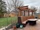 Backyard deck with seating area featuring a custom pergola and dining table with chairs and lush landscaping at 8212 N Sierra Dr, Muncie, IN 47303