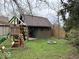 Private backyard featuring a play area, shed, fire pit, and lush green lawn at 8212 N Sierra Dr, Muncie, IN 47303