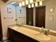 Bathroom featuring dual sinks, granite countertops, and a well-lit vanity mirror at 8212 N Sierra Dr, Muncie, IN 47303