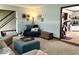 Inviting living room featuring neutral colors, a sectional sofa, ottoman, a cozy chair, and seamless flow to the kitchen at 8212 N Sierra Dr, Muncie, IN 47303