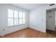Bright bedroom with hardwood floors, plantation shutters, and a view into the bathroom at 9029 Crook N Dr, Indianapolis, IN 46256