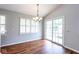 Bright dining room featuring wood floors, modern chandelier and sliding doors to the outside at 9029 Crook N Dr, Indianapolis, IN 46256