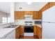 Cozy kitchen featuring wood cabinetry, white countertops, and modern appliances at 9029 Crook N Dr, Indianapolis, IN 46256