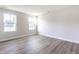A bright bedroom features two windows, light gray walls, and stylish gray-toned flooring at 955 Sand Hollow Dr, Lebanon, IN 46052