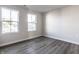 A bright bedroom features two windows, light gray walls, and stylish gray-toned flooring at 955 Sand Hollow Dr, Lebanon, IN 46052