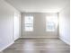 A bright bedroom features two windows, light gray walls, gray-toned flooring and a door at 955 Sand Hollow Dr, Lebanon, IN 46052