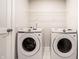 Modern laundry room featuring a washer, dryer, and wire rack at 955 Sand Hollow Dr, Lebanon, IN 46052