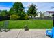 Large backyard featuring a well-maintained lawn, mature trees, privacy fence and a stone patio with outdoor seating at 10622 Young Lake Dr, Indianapolis, IN 46239