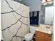 Charming bathroom with a shower featuring a patterned curtain and decorative blue towels at 10622 Young Lake Dr, Indianapolis, IN 46239