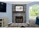 Close up of modern gray stone fireplace with black mantle and hearth with decorative tile work at 10622 Young Lake Dr, Indianapolis, IN 46239