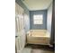 Cozy bathtub situated adjacent to a large window, which provides natural lighting at 1071 Hazelwood Dr, Greenwood, IN 46143