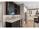 Modern kitchen boasts sleek, dark cabinetry, stainless steel appliances, and beverage refrigerator at 11450 Wicker Ln, Noblesville, IN 46060