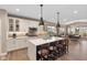 Modern kitchen boasts a large island, white cabinetry, stainless steel appliances, and hardwood floors at 11450 Wicker Ln, Noblesville, IN 46060