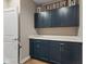 Convenient laundry room with navy cabinets, sleek hardware and a white countertop with an abundance of storage space at 11450 Wicker Ln, Noblesville, IN 46060