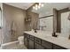 Bathroom featuring a double vanity with a modern mirror and a tiled shower with a glass door at 12658 Watford Way, Fishers, IN 46037