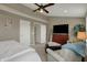 Bright bedroom featuring a ceiling fan, dresser with a television, and an oversized chair at 12658 Watford Way, Fishers, IN 46037