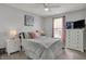Comfortable bedroom with a large window, decorative ceiling fan and bedside tables with lamps at 12658 Watford Way, Fishers, IN 46037