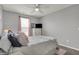 Comfortable bedroom with soft pink accents, a patterned ceiling, and a large window at 12658 Watford Way, Fishers, IN 46037