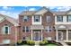 Charming two-story brick townhome featuring neat landscaping, gray shutters, and a welcoming front entrance at 12658 Watford Way, Fishers, IN 46037