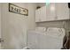 Functional laundry room features modern appliances and ample overhead storage for convenience at 12658 Watford Way, Fishers, IN 46037