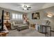 Cozy living room with comfortable seating, neutral walls, a ceiling fan and a window with plantation shutters at 12658 Watford Way, Fishers, IN 46037