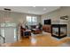 Spacious living room featuring hardwood floors, a leather sofa, fireplace, and ample natural light from windows at 12658 Watford Way, Fishers, IN 46037