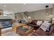 Open-concept living space with hardwood floors, a fireplace, leather sofa, and dining area, perfect for entertaining at 12658 Watford Way, Fishers, IN 46037