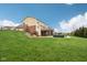 Expansive backyard featuring a two-story deck, patio, manicured lawn, and partial privacy fence at 13974 Nina Dr, Carmel, IN 46074