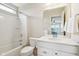 Well-lit bathroom with a shower-tub combo, a stylish vanity, and a mirrored wall at 13974 Nina Dr, Carmel, IN 46074