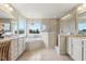 Bright bathroom features double sinks, a soaking tub under a window, and a glass-enclosed shower, all with elegant fixtures at 13974 Nina Dr, Carmel, IN 46074